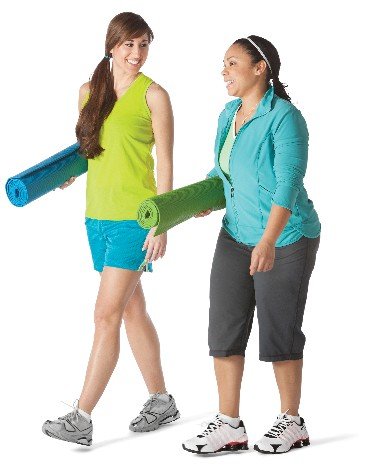 Two women walking and holding yoga mats